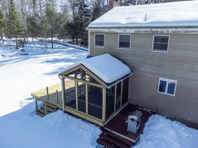 exterior space featuring a chimney and a sunroom