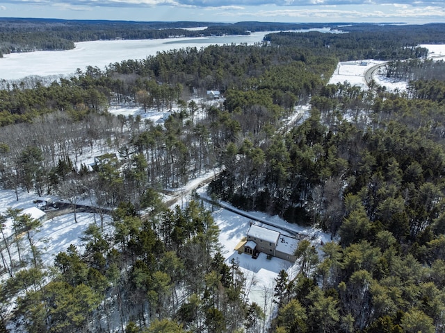 snowy aerial view with a water view and a wooded view