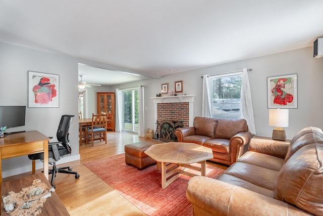 living room with a brick fireplace and wood finished floors