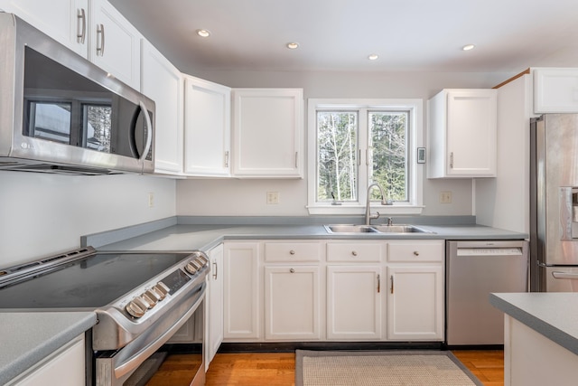 kitchen featuring white cabinetry, appliances with stainless steel finishes, a sink, and recessed lighting