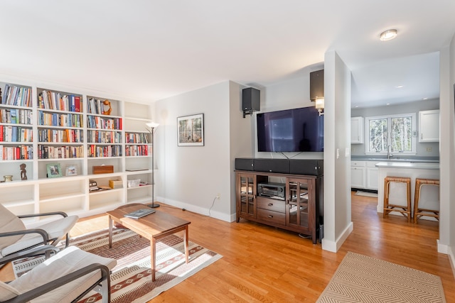 living area with light wood-type flooring and baseboards