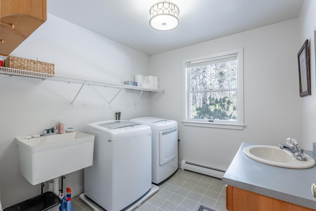 washroom featuring laundry area, baseboard heating, a sink, and washing machine and clothes dryer