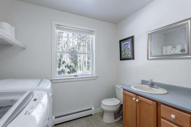 bathroom with toilet, washing machine and clothes dryer, tile patterned flooring, vanity, and a baseboard heating unit