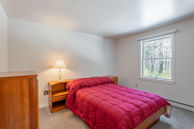 bedroom with a baseboard heating unit and carpet flooring