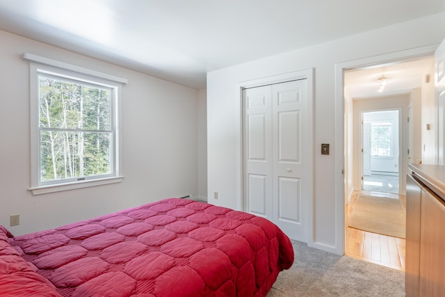 bedroom with light carpet and a closet