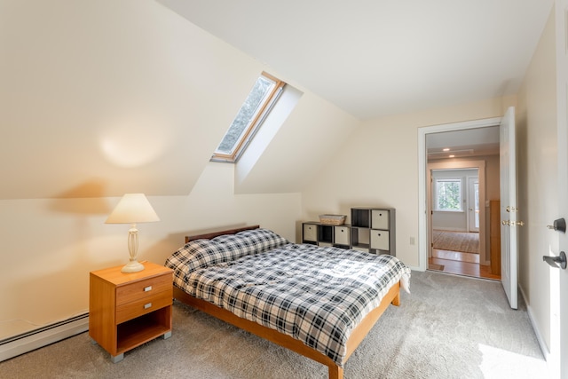 bedroom featuring lofted ceiling with skylight, baseboards, light carpet, and baseboard heating