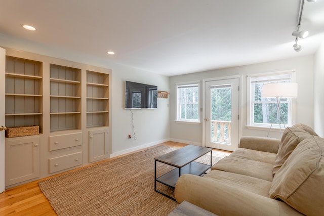 living room with light wood-style floors, plenty of natural light, baseboards, and recessed lighting