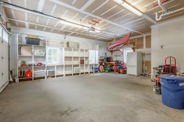 garage featuring freestanding refrigerator and a garage door opener