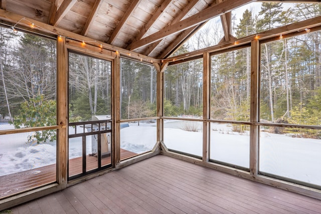 unfurnished sunroom with vaulted ceiling with beams, plenty of natural light, and wood ceiling