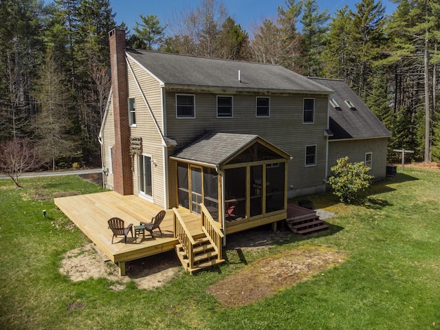 27 Libby Ln, Brunswick, ME 04011 - back of property featuring a chimney, a lawn, a sunroom, a shingled roof, and a wooden deck