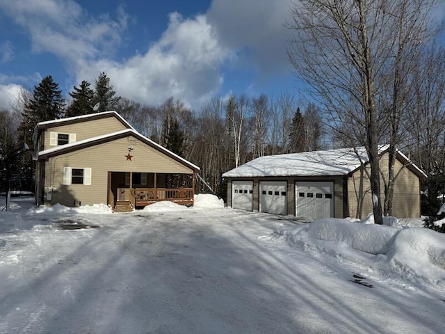 9 Ledge Dr, Greenville, ME 04441 - view of snow covered exterior featuring an outdoor structure, a detached garage, and covered porch