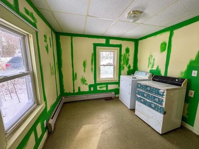 laundry room featuring laundry area, baseboards, baseboard heating, washer and dryer, and a baseboard heating unit