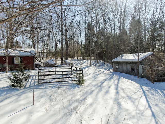 snowy yard featuring an outbuilding