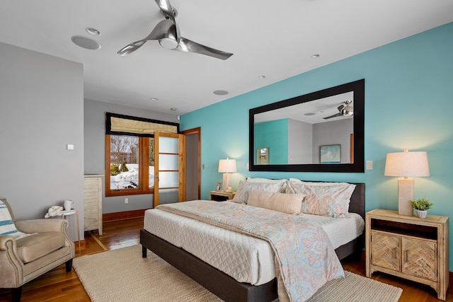 bedroom featuring ceiling fan, baseboards, and wood finished floors