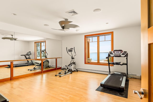 workout area featuring a baseboard radiator, visible vents, ceiling fan, and wood finished floors