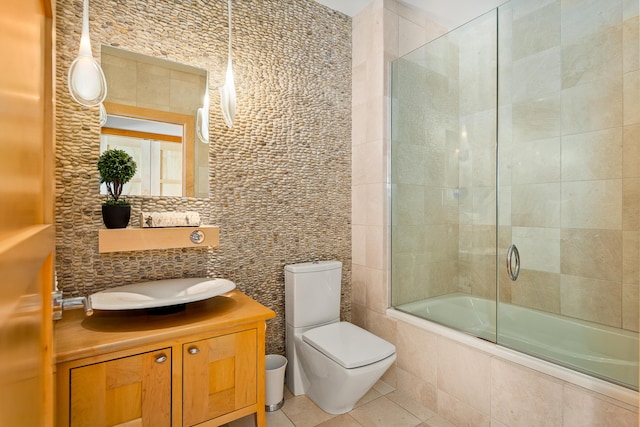 bathroom featuring tile walls, tile patterned flooring, tiled shower / bath, vanity, and backsplash