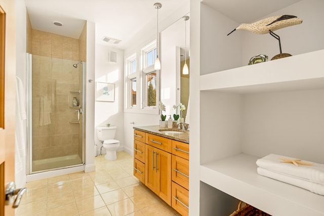 bathroom featuring toilet, visible vents, vanity, a tile shower, and tile patterned floors