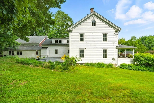 49 Old Village Rd, Winthrop, ME 04364 - rear view of house featuring a patio area, a chimney, and a lawn
