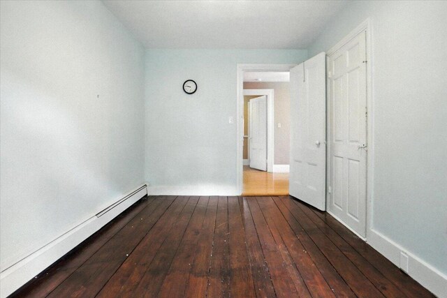49 Old Village Rd, Winthrop, ME 04364 - unfurnished bedroom featuring a baseboard radiator and dark wood-style floors