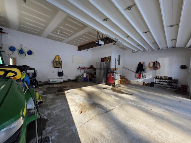 garage with freestanding refrigerator and a garage door opener