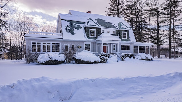 view of front of property with a chimney and a sunroom