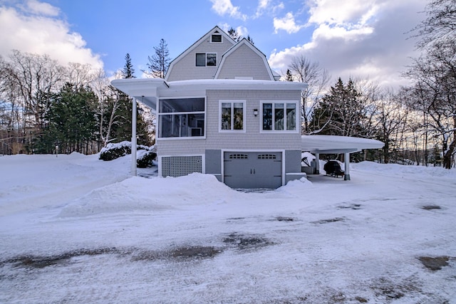 view of front facade with a garage and a gambrel roof