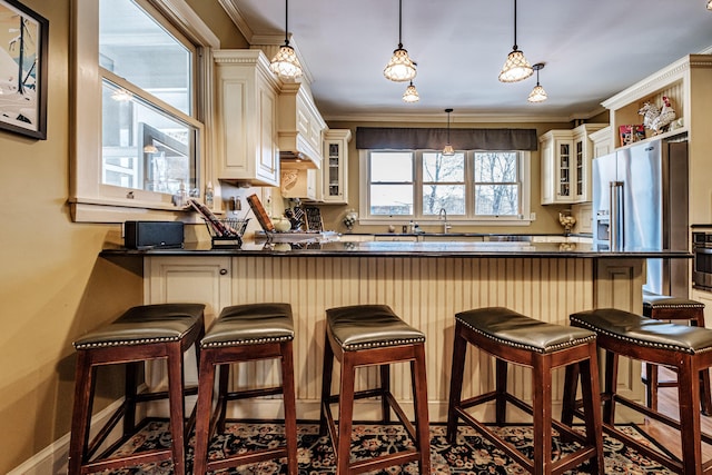 kitchen with dark countertops, glass insert cabinets, and a kitchen breakfast bar