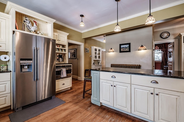 kitchen featuring dark countertops, a kitchen bar, pendant lighting, and stainless steel appliances