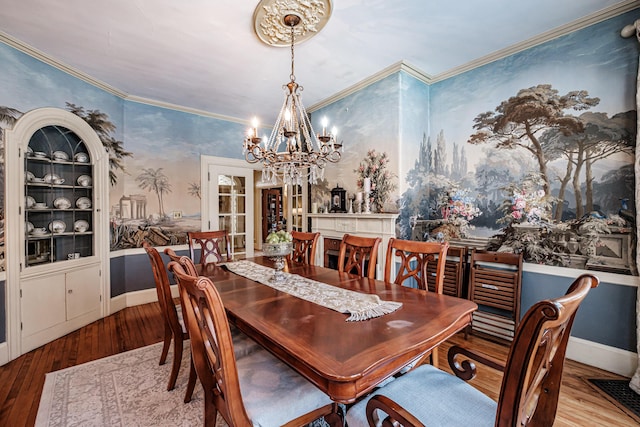 dining space with wallpapered walls, baseboards, wood finished floors, crown molding, and a notable chandelier