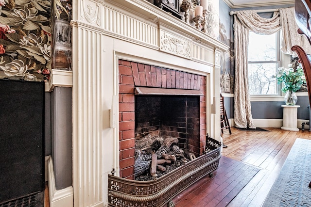 room details with a brick fireplace, baseboards, and wood finished floors