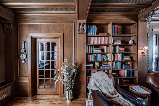 unfurnished room with beamed ceiling, wood walls, and wood finished floors