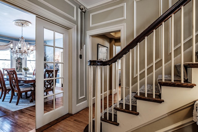 doorway with a chandelier, stairway, and wood finished floors