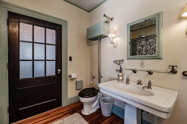 bathroom featuring baseboards, toilet, and wood finished floors