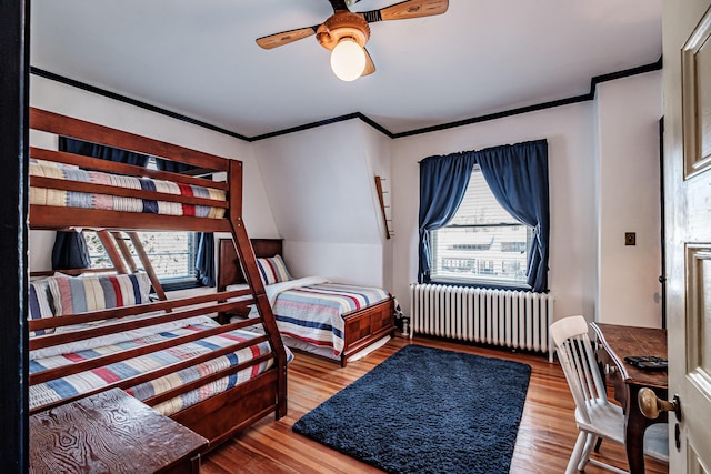 bedroom featuring radiator heating unit, crown molding, and wood finished floors