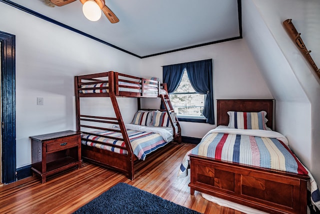 bedroom with ceiling fan, wood finished floors, and crown molding