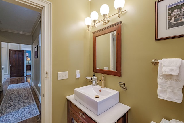 bathroom featuring crown molding, vanity, and wood finished floors