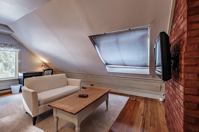 living area featuring lofted ceiling, wood walls, and light wood-style floors