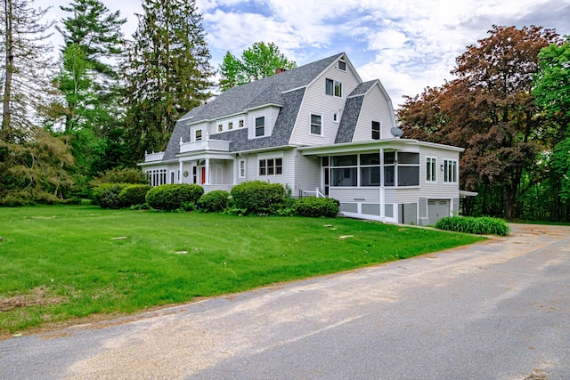 67 Broad St, Bethel, ME 04217 - view of front of home with a sunroom, a garage, a gambrel roof, a shingled roof, and a chimney