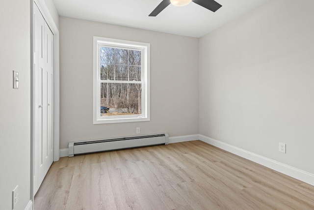 unfurnished bedroom with baseboards, wood finished floors, a closet, a ceiling fan, and a baseboard radiator