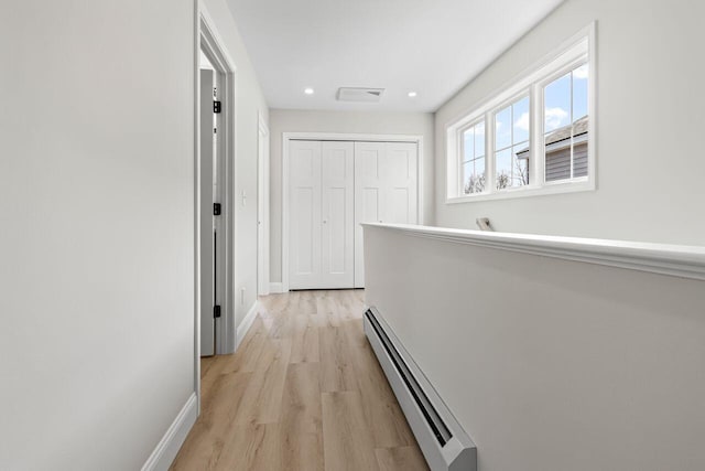 corridor featuring recessed lighting, light wood-type flooring, baseboards, and a baseboard radiator