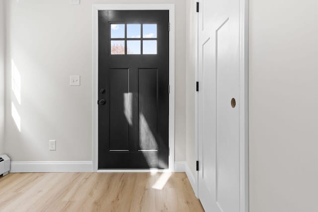 foyer entrance with baseboards and wood finished floors