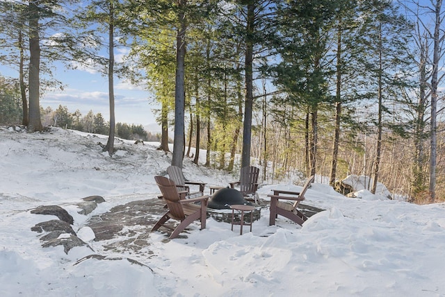 yard covered in snow featuring an outdoor fire pit