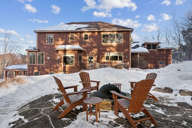 view of snow covered back of property