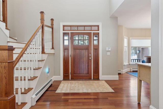 entrance foyer with dark wood-style flooring, baseboard heating, and a healthy amount of sunlight