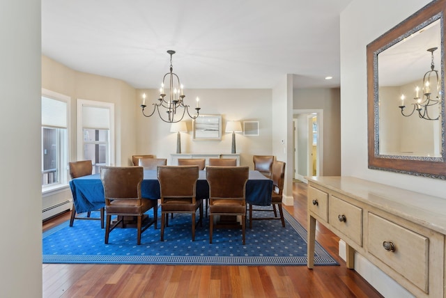 dining area featuring a chandelier, a baseboard radiator, and dark wood-style flooring