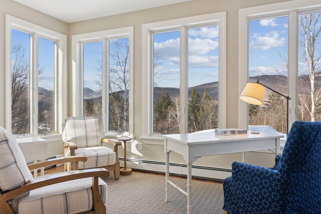 sunroom with a baseboard radiator and a mountain view