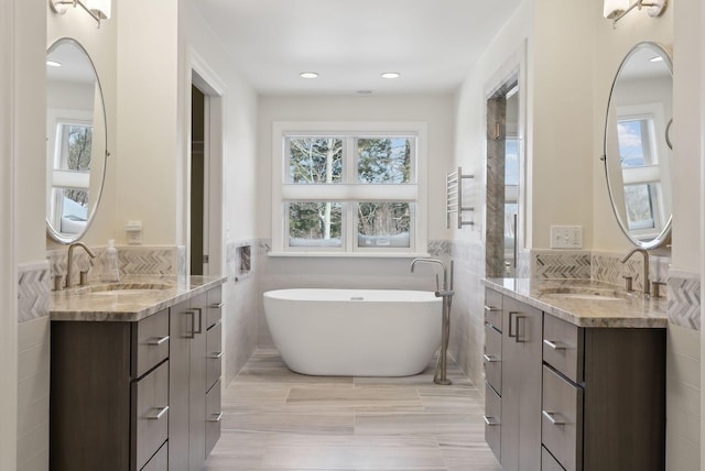 bathroom with two vanities, a sink, and wainscoting