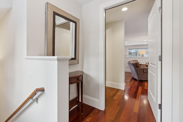 corridor featuring dark wood-type flooring, recessed lighting, an upstairs landing, and baseboards