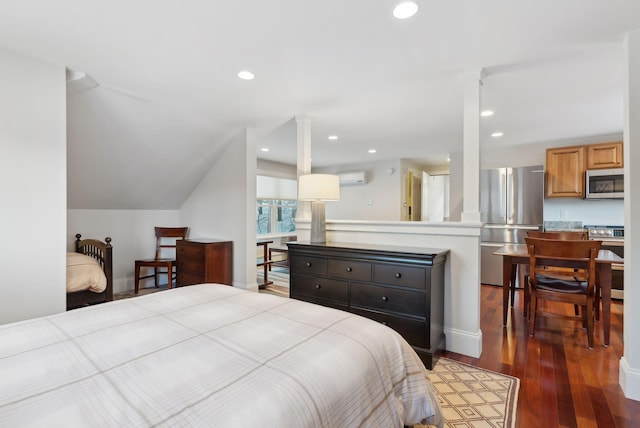 bedroom with a wall unit AC, dark wood finished floors, recessed lighting, freestanding refrigerator, and ornate columns