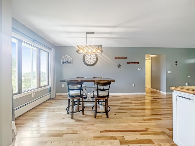 dining room featuring baseboards, light wood-style flooring, and baseboard heating